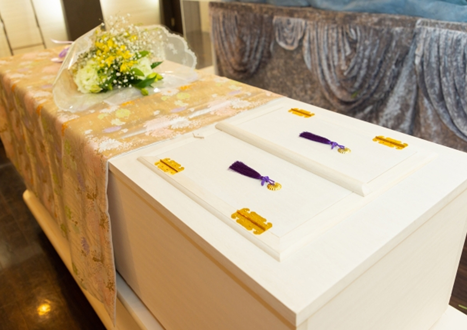 白木の棺と花束が並ぶ火葬式の祭壇をメモサのお葬式が神戸市で用意している