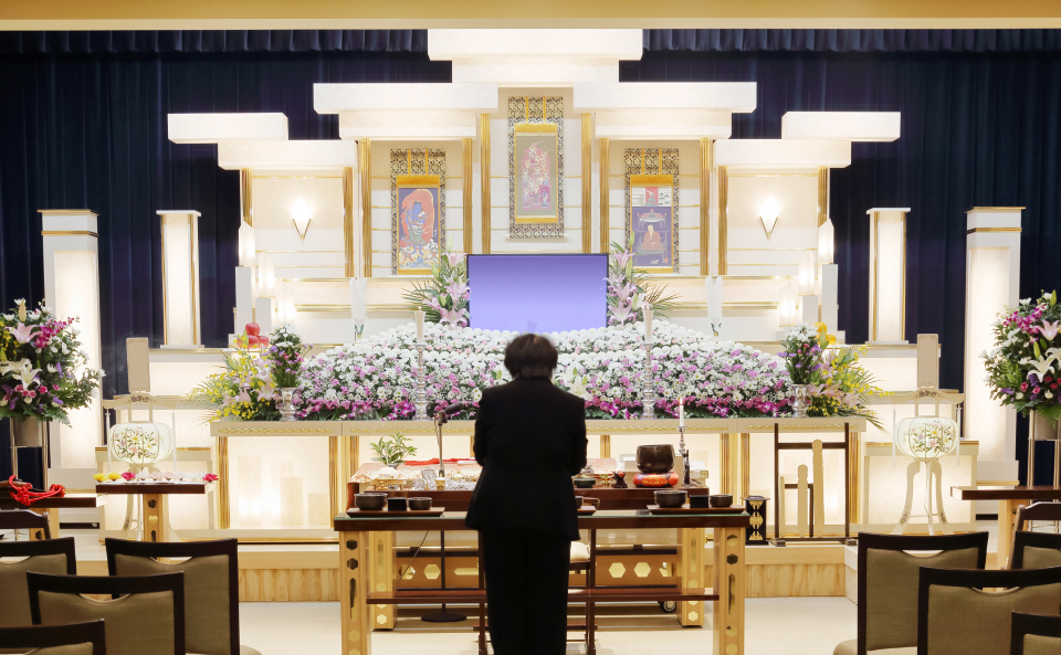 メモサのお葬式が神戸市で祭壇と花に囲まれた式場で事前相談を案内している